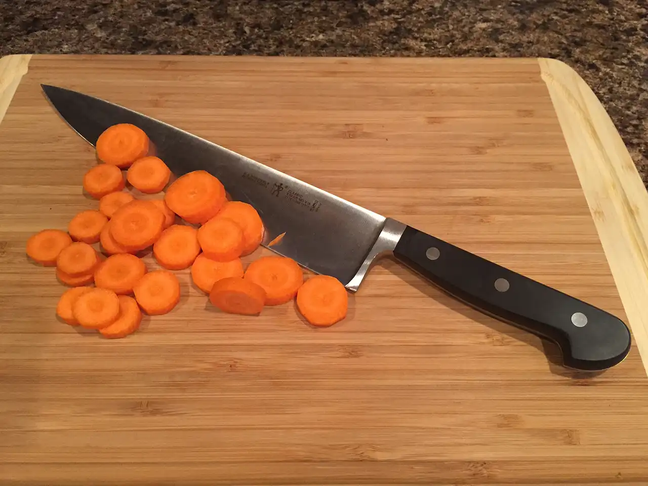 https://steelbluekitchen.com/wp-content/uploads/2021/11/JA-Henckles-Classic-Knife-Cutting-Carrots.webp